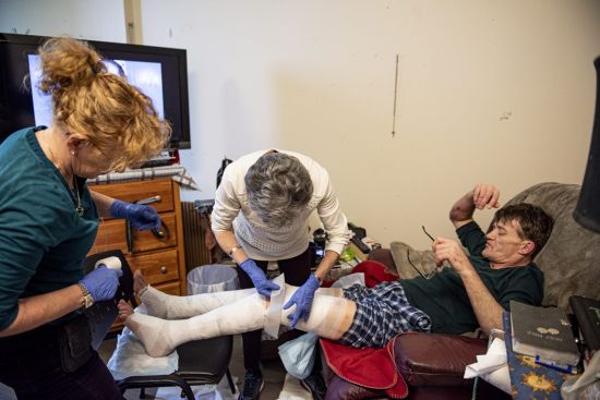 Susan Giles (L) and Evanna Brennan (R) tend to a patient in the Downtown Eastside.